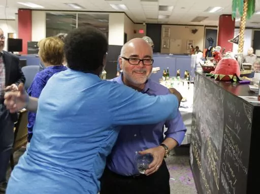 Charlotte Observer editorial cartoonist Kevin Siers, right, gets a hug from a co-worker as the newsroom as they celebrate Siers winning the Pulitzer Prize for Editorial Cartooning at the newspaper in Charlotte, N.C., on Monday, April 14, 2014. Siers was among three Pulitzer Prize-winning editorial cartoonists who were laid off last week. (AP Photo/Chuck Burton, File)