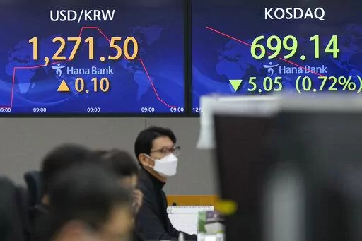 A currency trader watches computer monitors near the screens showing the foreign exchange rate between U.S. dollar and South Korean won at a foreign exchange dealing room in Seoul, South Korea, Wednesday, Dec. 28, 2022. Shares were mixed in Asia on Wednesday after a post-holiday retreat on Wall Street, as markets count down to the end of a painful year for investors.(AP Photo/Lee Jin-man)