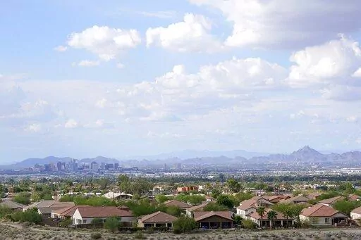 FILE -With the downtown skyline in the background, expansive urban sprawl continues to grow, Thursday, Aug. 12, 2021, in Phoenix. A county in the heart of metro Phoenix and several counties in Texas' fastest-growing metro areas had the biggest jumps in the numbers of white, Black, Asian and Hispanic residents last year, while California's Inland Empire also had among the biggest booms in Hispanic residents, according to new estimates released Thursday, June 30, 2022 (AP Photo/Ross D. Franklin, F