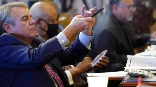 Sen. Michael McLendon, R-Hernando, photographs examples of hemp product, used to illustrate to lawmakers what specific portions of the Mississippi Medical Cannabis Equivalency Units would look like, during the presentation of the Mississippi Medical Cannabis Act in the Senate Chamber at the Mississippi State Capitol in Jackson, Miss., Thursday, Jan. 13, 2022. The body passed the act. (AP Photo/Rogelio V. Solis)