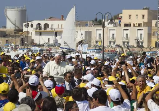 Pope Francis waves to faithful as he is driven through the crowd during his visit to the island of Lampedusa, southern Italy, on July 8, 2013, where he denounced the "globalization of indifference" that greets migrants who risk their lives trying to reach Europe. Pope Francis' first 10 years as pope have been marked by several historic events, as well as several unplanned moments or comments that nevertheless helped define the contours and priorities of history's first Latin American pope. (AP P