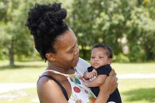 Venessa Aiken holds her son Jahzir Robinson, five weeks old, outside their home Sunday, Aug. 21, 2022, in Orlando, Fla. States around the country are making it easier for newborn moms to keep Medicaid in the year after childbirth, a crucial time when depression and other health problems can develop.(AP Photo/John Raoux)