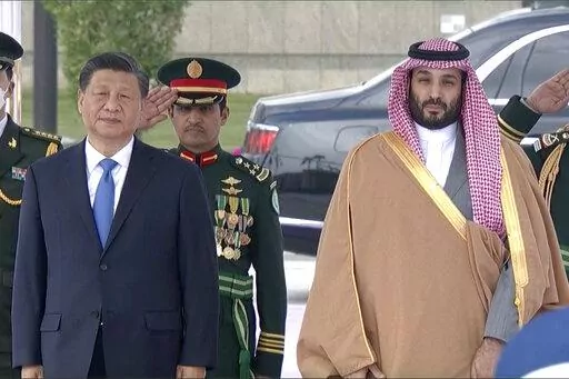 In this image taken from footage by Saudi State TV, Chinese President Xi Jinping, left, listens to the Chinese national anthem next to Saudi Crown Prince and Prime Minister Mohammed bin Salman in Riyadh, Saudi Arabia, Thursday, Dec. 8, 2022. (Saudi Press Agency via AP)