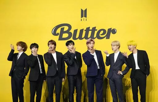 FILE- Members of South Korean K-pop band BTS, V, SUGA, JIN, Jung Kook, RM, Jimin, and j-hope from left to right, pose for photographers ahead of a press conference to introduce their new single "Butter" in Seoul, South Korea, Friday, May 21, 2021. Three members of the K-pop superstar group BTS have been infected with the coronavirus.  the Big Hit Entertainment agency says in a statement that RM and Jin were diagnosed with COVID-19 on Saturday evening. It earlier said another member, Suga, teste