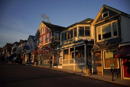 Early-morning light shines on shops on Main Street, June 11, 2022, in Bar Harbor, Maine. Small businesses face a mix of old and new challenges as 2023 begins. Regulations are a double-edged sword. They’re created to improve business dealings, discourage unfair or illegal business activity, and protect workers. But, for small business owners, they often mean more red tape, higher costs and possible penalties for failing to comply. (AP Photo/Robert F. Bukaty, File)