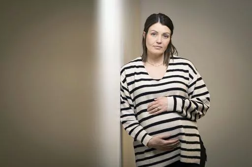 Jillaine St.Michel stands for a portrait in Boise, Idaho on Saturday, Dec. 2, 2023. A year earlier, she learned that her previous 20-week fetus had multiple genetic and developmental problems and probably wouldn’t survive. She lives in Idaho, which has a ban on abortions, so St.Michel and her husband called about 15 out-of-state clinics, finally getting on a three-week waiting list in Denver and a two-week waiting list in Seattle. Pregnant again, she is due to give birth to a boy in January. (