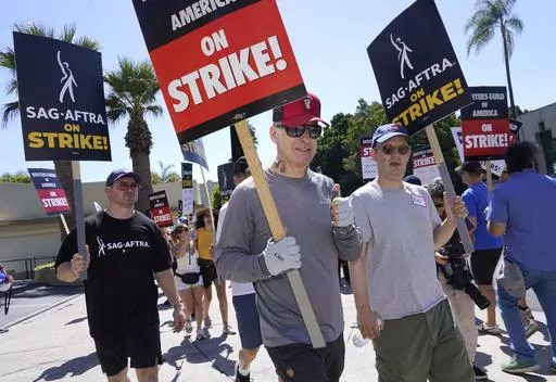 Actor Bob Odenkirk, center, carries a sign on a picket line outside Paramount studios on Wednesday, July 19, 2023, in Los Angeles. The actors strike comes more than two months after screenwriters began striking in their bid to get better pay and working conditions. (AP Photo/Chris Pizzello)