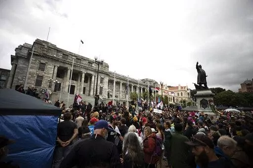 People who oppose vaccine mandates protest at Parliament in Wellington, New Zealand Monday, Feb. 14, 2022. The protesters are not planning to leave any time soon after they drove in convoys from around the country nearly a week ago, setting up tents on Parliament's grounds and blocking surrounding streets with their cars and trucks. (George Heard/New Zealand Herald via AP)