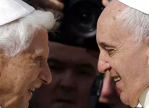 Pope Francis, right, greets Pope Emeritus Benedict XVI prior to the start of a meeting with elderly faithful in St. Peter's Square at the Vatican, on Sept. 28, 2014. Emeritus Pope Benedict XVI turned 95 this past weekend, a significant milestone on its own but even more given he has now been a retired pope longer than he was a reigning one.  To mark the occasion, a new book published Thursday, April 21, 2022 sets out to examine the current state of Vatican affairs not so much through the lens of