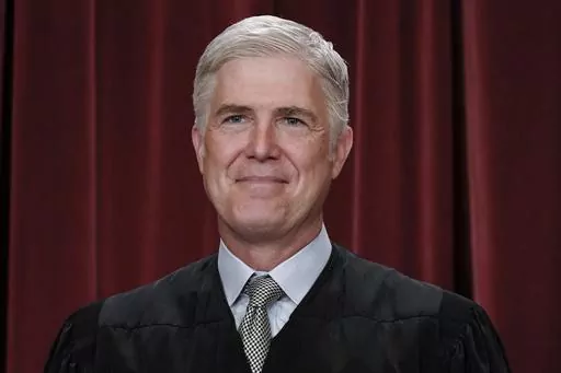 Associate Justice Neil Gorsuch joins other members of the Supreme Court as they pose for a new group portrait, at the Supreme Court building in Washington, Friday, Oct. 7, 2022. Gorsuch called emergency measures taken during the COVID-19 crisis that killed more than 1 million Americans perhaps “the greatest intrusions on civil liberties in the peacetime history of this country.” The 55-year-old conservative justice pointed to orders closing schools, restricting church services, mandating vac