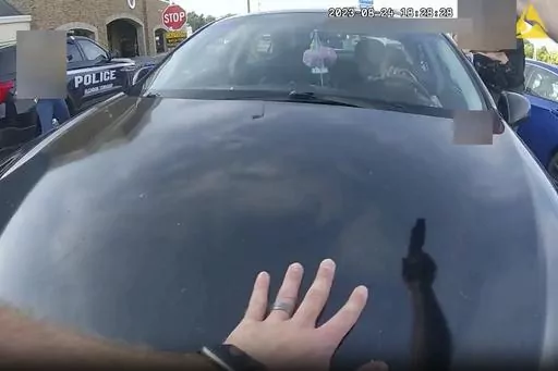 This image from bodycam video released by the Blendon Township Police on Friday, Sept. 1, 2023, shows an officer pointing his gun at Ta'Kiya Young moments before shooting her through the windshield outside a grocery store in Blendon Township, Ohio, a suburb of Columbus, on Aug. 24. The pregnant Black mother was pronounced dead shortly after the shooting. Her unborn daughter did not survive. The image was pixelated by the source. (Blendon Township Police via AP, File)