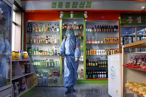 An employee of the Kyonghung Foodstuff General Store disinfects the showroom in Pyongyang, North Korea, Wednesday, Nov. 10, 2021. Before acknowledging domestic COVID-19 cases, Thursday, May 12, 2022, North Korea spent 2 1/2 years rejecting outside offers of vaccines and steadfastly claiming that its superior socialist system was protecting its 26 million people from “a malicious virus” that had killed millions around the world. (AP Photo/Jon Chol Jin, File)