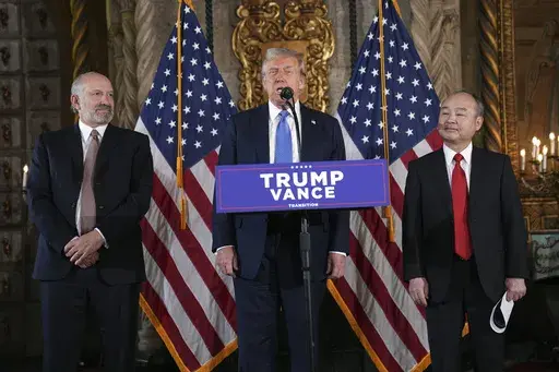 President-elect Donald Trump speaks during a news conference at Mar-a-Lago, Monday, Dec. 16, 2024, in Palm Beach, Fla., as SoftBank Group CEO Masayoshi Son, right, and Commerce Secretary nominee Howard Lutnick listen. (AP Photo/Evan Vucci)