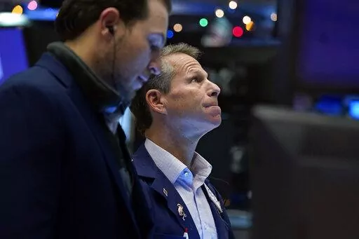 Trader Robert Charmak, right, works on the floor of the New York Stock Exchange, Tuesday, Dec. 7, 2021.  (AP Photo/Richard Drew, File)
