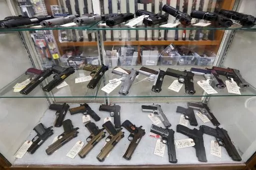Semi-automatic handguns are displayed at shop in New Castle, Pa., March 25, 2020. A federal appeals court has dealt a legal setback to the Biden administration on guns in a lawsuit challenging tighter regulations on stabilizing braces, an accessory used in several mass shootings. The Fifth Circuit Court of Appeals temporarily blocked an administration rule from going into effect for the gun owners and groups who filed the lawsuit. The order came shortly before a deadline for people to register t