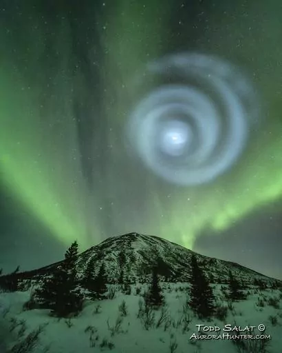 In this photo provided by Todd Salat, northern light enthusiasts got a surprise early April 15, 2023, when something odd was mixed in with the green bands of light dancing above the Donnelly Dome near Delta Junction, Alaska. A light baby blue spiral resembling a galaxy appeared amid the aurora for a few minutes. The spiral was formed when excess fuel that had been released from a SpaceX rocket that launched from California about three hours earlier turned to ice, and then the water vapor reflect
