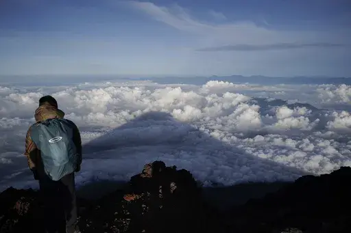 The shadow of Mount Fuji is cast on clouds hanging below the summit Aug. 27, 2019, in Japan. Three bodies were found inside a crater at the summit of Mount Fuji, Japan’s most famous mountain, with one of them already brought down from the slopes, police said Thursday, June 27, 2024. (AP Photo/Jae C. Hong, File)