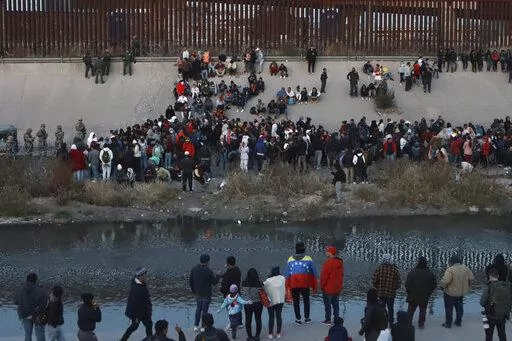 Migrants gather at a crossing into El Paso, Texas, as seen from Ciudad Juarez, Mexico, Tuesday, Dec. 20, 2022. Tensions remained high at the U.S-Mexico border Tuesday amid uncertainty over the future of restrictions on asylum-seekers, with the Biden administration asking the Supreme Court not to lift the limits before Christmas. (AP Photo/Christian Chavez)