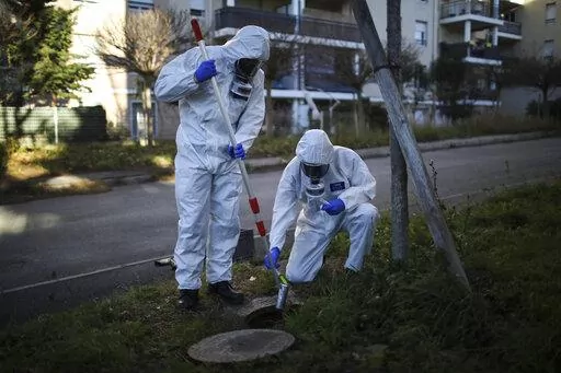 Firefighters from the Marins-Pompiers of Marseille extract samples of sewage water at a retirement home in Marseille, southern France, Thursday Jan. 14, 2021, to trace concentrations of COVID-19 and the highly contagious variant that has been discovered in Britain. As coronavirus infections rise in some parts of the world, experts are watching for a potential new COVID-19 surge in the U.S. — and wondering how long it will take to detect. (AP Photo/Daniel Cole)