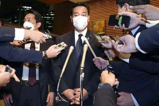 Japan's Economy Minister Daishiro Yamagiwa is surrounded by reporters at the prime minister's official residence in Tokyo, Monday, Oct. 24, 2022. Yamagiwa on Monday said he submitted his resignation to Prime Minister Fumio Kishdia over his ties to the Unification Church after facing mounting criticisms that he lacked explanations in a widening controversy that has involved dozens of other party lawmakers and rocked Kishida’s government.(Kyodo News via AP)