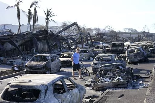 A man walks through wildfire wreckage in Lahaina, Hawaii, Aug. 11, 2023. Federal authorities have started removing hazardous materials from the Maui wildfires and laying the groundwork to dispose of burnt cars, buildings and other debris. The hazardous materials, including oil, solvent and batteries, are being shipped to the West Coast while the U.S. Army Corps of Engineers works with local officials to develop a plan to dispose of an estimated 400,000 to 700,000 tons of debris on the island. (A