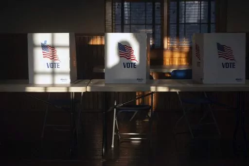 The shadow of a voter entering the precinct at St. Joseph Catholic Church in Gluckstadt, Miss., is cast on a privacy divider for people filling out ballots at Precinct 205 at during the primary election Tuesday, March 12, 2024. (Barbara Gauntt/The Clarion-Ledger via AP)