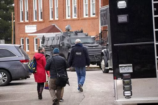 Police vehicles sit in front of University Hill Elementary School across from the campus of the University of Colorado after Matthew Harris,  accused of making violent threats against the college as well as the University of California, Los Angeles, was taken into custody following a standoff at his Boulder apartment complex Tuesday, Feb. 1, 2022, in Boulder, Colo. A trail of red flags about his behavior toward women followed Harris, a former lecturer at UCLA, on an academic journey that took hi