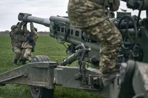 Ukrainian soldiers prepare a U.S.-supplied M777 howitzer to fire at Russian positions in Kherson region, Ukraine, Jan. 9, 2023. A rapidly expanding group of U.S. and allied troops and contractors are using phones and tablets to communicate in encrypted chat rooms to provide real-time maintenance advice to Ukrainian troops on the battlefield. As the U.S. and other allies provide a growing number of increasingly complex and high-tech weapons, the maintenance demands are expanding. (AP Photo/Libkos