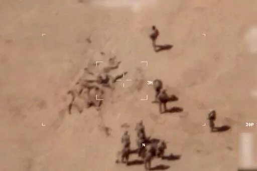 This image taken from a video shows soldiers burying bodies near an army base in northern Mali. The French military says it has videos of Russian mercenaries burying bodies near an army base in northern Mali which it says is part of a smear campaign against the French who handed control of the base to Malian forces earlier this week. Aerial surveillance taken by the French military early Thursday and provided to The Associated Press show what appear to be 10 Caucasian soldiers covering approxima