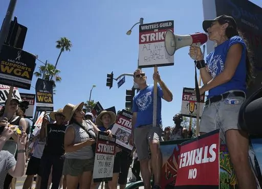Actor and filmmaker Justine Bateman, right, speaks outside Netflix during a Writers Guild rally on July 13, 2023, in Los Angeles. Bateman said she was disturbed that AI models were "ingesting 100 years of film" and TV in a way that could destroy the structure of the film business and replace large portions of its labor pipeline. (AP Photo/Mark J. Terrill, File)