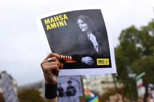 A protester shows a portrait of Mahsa Amini during a demonstration to support Iranian protesters standing up to their leadership over the death of a young woman in police custody, Sunday, Oct. 2, 2022 in Paris.  Anti-government demonstrations erupted Saturday, Oct. 8,  in several locations across Iran as the most sustained protests in years against a deeply entrenched theocracy entered their fourth week. The protests erupted Sept. 17, after the burial of 22-year-old Amini, a Kurdish woman who ha