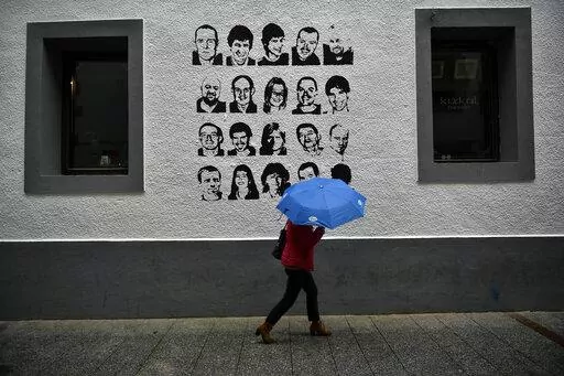 A woman shelters from the rain under an umbrella, while walking past a wall painted with portraits of prisoners of the Basque separatist armed group ETA, in the small village of Hernani, northern Spain, May 2, 2018. The United States is poised to remove five extremist groups, all believed to be defunct, from its list of foreign terrorist organizations. Several of these groups once posed significant threats, killing hundreds if not thousands of people across Asia, Europe and the Middle East. The 