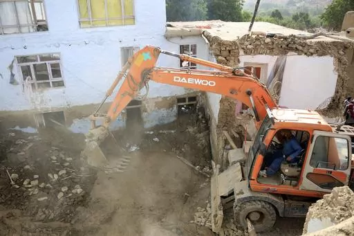 An excavator removes mud from a damaged house after heavy flooding in the Maidan Wardak province in the central of Afghanistan, Sunday, July 23, 2023. Heavy flooding from seasonal rains in Afghanistan killed multiple people and left dozens missing over the past three days. (AP Photo)