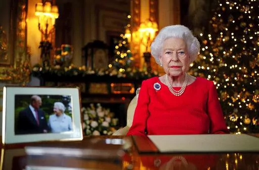 In this undated photo issued on Dec. 23, 2021, Britain's Queen Elizabeth II records her annual Christmas broadcast in Windsor Castle, Windsor, England. The United Kingdom will celebrate Queen Elizabeth II’s 70 years on the throne with a military parade, neighborhood parties and a competition to create a new dessert for the Platinum Jubilee, Buckingham Palace said Monday, Jan. 10, 2022. (Victoria Jones/Pool Photo via AP, File)
