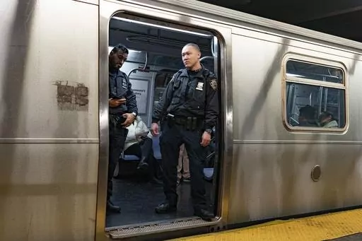 NYPD officers stand aboard a train at the West Fourth Street subway station, Saturday, Jan. 13, 2024, in New York. Prosecutors say a man who shot and critically wounded another man on a New York City subway train will not immediately be charged with a crime while prosecutors investigate whether the shooter acted justifiably in self-defense.(AP Photo/Peter K. Afriyie, File)