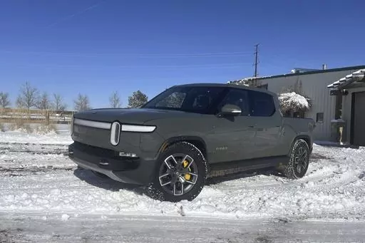 This photo provided by Edmunds shows a Rivian R1T electric pickup near Boulder, Colorado. Many of the potential problems of driving an electric vehicle in cold weather can be offset by planning ahead. (Emme Hall/Edmunds via AP)