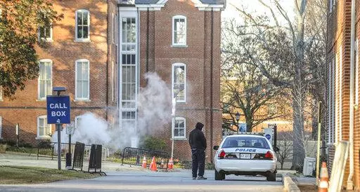 A man speaks with a police officer in a patrol vehicle outside the Spelman campus, Feb. 1, 2022. after two historically Black colleges in Georgia received bomb threats.  Vice President Kamala Harris is set to announce that historically Black colleges and universities, many of which recently received bomb threats, are eligible for federal campus security grants. (John Spink/Atlanta Journal-Constitution via AP, File)