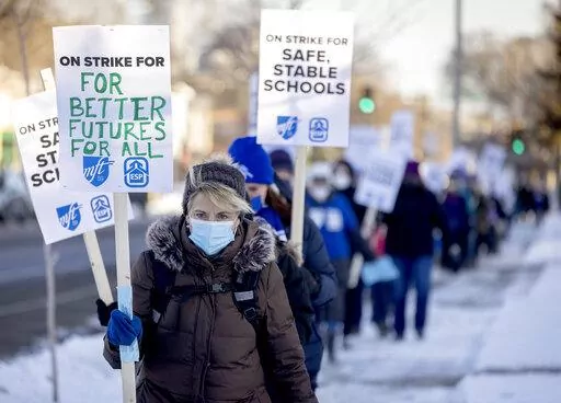 Minneapolis teachers and supporters picket at 34th street and Chicago Avenue South in Minneapolis, on Tuesday, March 8, 2022.   Teachers walked off the job on Tuesday in a dispute over wages, class sizes and mental health support for students coping with two years of the coronavirus pandemic, at least temporarily pausing classes for about 29,000 students in one of Minnesota's largest school districts. (Elizabeth Flores/Star Tribune via AP)