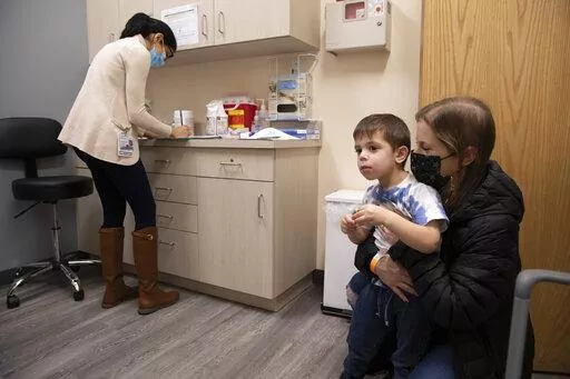 Ilana Diener holds her son, Hudson, 3, during an appointment for a Moderna COVID-19 vaccine trial in Commack, N.Y. on Nov. 30, 2021. On Wednesday, March 23, 2022, Moderna said its COVID-19 vaccine works in babies, toddlers and preschoolers, and if regulators agree it could mean a chance to finally start vaccinating the littlest kids by summer. (AP Photo/Emma H. Tobin)