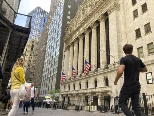 Pedestrians walk by the New York Stock Exchange, Wednesday, May 18, 2022 in New York. Stocks closed sharply lower on Wall Street Wednesday as dismal results from Target renewed fears that inflation is battering U.S. companies. The S&P 500, the benchmark for many index funds, fell 4%. Target lost a quarter of its value, dragging other retailers down with it, after saying its profit fell by half in the latest quarter as costs for freight and transportation spiked. That comes a day after Walmart ci