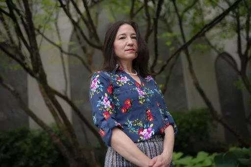 Allyson Jacobs stands for a portrait outside her workplace, Wednesday, May 4, 2022, in New York. For Jacobs, life in her 20s and 30s was about focusing on her career in health care and enjoying the club scene in New York City. It wasn't until she turned 40 that she and her husband started trying to have children. They had a son when she was 42.   (AP Photo/John Minchillo)
