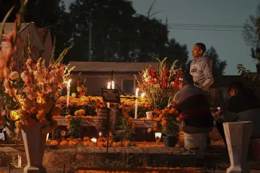 Families gather by the tomb of their dearly departed, as they celebrate the Day of the Dead, at the San Gregorio Atlapulco cemetery on the outskirts of Mexico City, Friday, Nov. 1, 2024. (AP Photo/Moises Castillo)