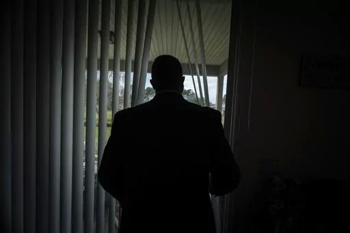 Joseph Moore looks out of a window at his home in Jacksonville, Fla., on Tuesday, Dec. 7, 2021. Moore worked for nearly 10 years as an undercover informant for the FBI, infiltrating the Ku Klux Klan in Florida, foiling at least two murder plots, according to investigators, and investigating ties between law enforcement and the white supremacist organization. "From where I sat, with the intelligence laid out, I can tell you that none of these agencies have any control over any of it. It is more p
