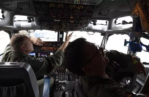 Pilots work in the cockpit of an AWACS plane at Melsbroek military airport in Melsbroek, Belgium, Wednesday, Nov. 27, 2019. As Russia’s military buildup near Ukraine accelerated early this year, military planners at NATO began preparing to dispatch scores of fighter jets and surveillance aircraft into the skies near Russia and Ukraine. It was a warning to Moscow not to make the mistake of targeting any member country. (AP Photo/Virginia Mayo, File)