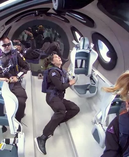 This photo released by Virgin Galactic shows mission specialist Jamila Gilbert, center, looking out one of the portal windows as she experiences weightlessness during a test flight on Thursday, May 25, 2023. Virgin Galactic completed what’s expected to be its final test flight Thursday before taking paying customers on brief trips to space. (Virgin Galactic via AP)