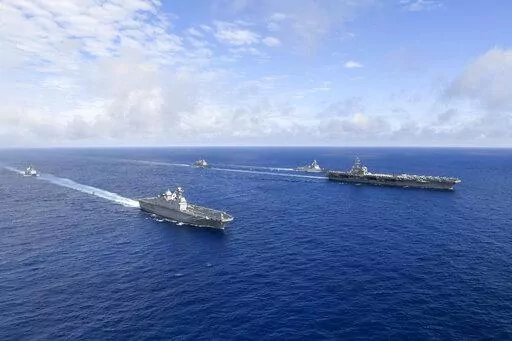 In this photo provided by South Korea's Defense Ministry, U.S. nuclear-powered aircraft carrier USS Ronald Reagan, right, and South Korea's landing platform helicopter (LPH) ship Marado, second from left, sail during a joint military exercise at an undisclosed location, Saturday, June 4, 2022. (South Korea Defense Ministry via AP)
