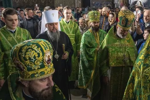 Metropolitan Epiphanius, head of the Orthodox Church of Ukraine, center, conducts the Palm Sunday service at Kiev-Pechersk Lavra monastery, Ukraine's most revered Orthodox site in Kyiv, Ukraine, Sunday, April 9, 2023. (AP Photo/Adam Pemble)