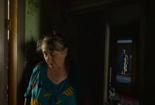 70-year-old Valentyna Klymenko, who lives alone in her war-damaged building from Russian aerial bombs, walks in her hallway, in Borodyanka, Kyiv region, Ukraine, Tuesday, June 28, 2022. Then Klymenko returns, alone, to an apartment that used to be noisy and full of life. Now, instead of the voices of her great-grandchildren, she is greeted by dim, damp rooms. She rarely cooks. She drinks fruit compote and eats canned tomatoes, which she prepared last year, so as not to waste the gas in her porta