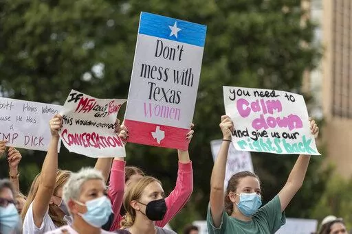 FILE -People take part in the Women's March ATX rally, Saturday, Oct., 2, 2021 in at the Texas State Capitol in Austin, Texas. Texas has released data showing a marked drop in abortions at clinics in the state in the first month under the nation's strictest abortion law, but that only tells part of the story, Friday, Feb. 25, 2022. (AP Photo/Stephen Spillman, File)