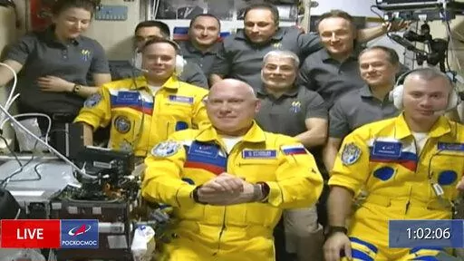 In this frame grab from video provided by Roscosmos, Russian cosmonauts Sergey Korsakov, Oleg Artemyev and Denis Matveyev are seen during a welcome ceremony after arriving at the International Space Station, Friday, March 18, 2022, the first new faces in space since the start of Russia’s war in Ukraine. The crew emerged from the Soyuz capsule wearing yellow flight suits with blue stripes, the colors of the Ukrainian flag. (Roscosmos via AP)